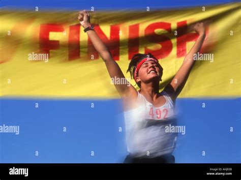 woman runner crossing finish   track meet stock photo