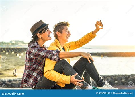 Happy Gay Couple Taking A Selfie With Mobile Smart Phone Camera On The