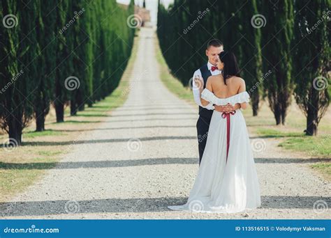 happy stylish smiling couple walking and kissing in tuscany ita stock