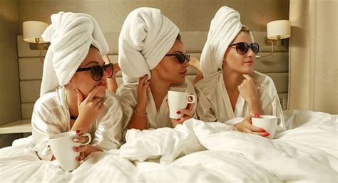 women  bathrobes sitting   bed drinking coffee  talking