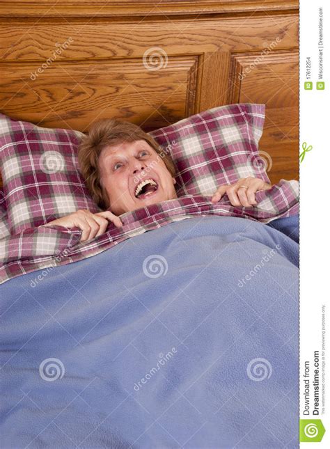 rijpe hogere doen schrikken vrouw bang gemaakt in bed stock foto afbeelding bestaande uit