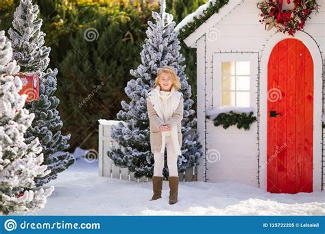 Cute Blonde Girl Playing With Snow Near The Small House And Snow