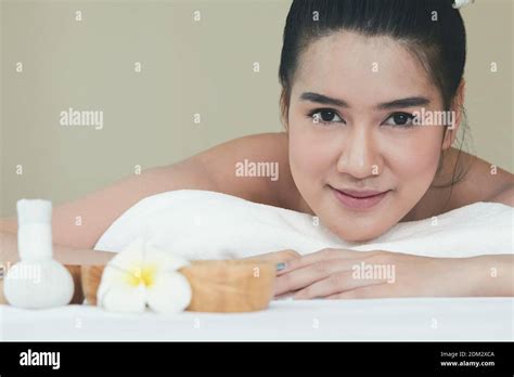 Close Up Portrait Of Smiling Woman Lying On Massage Table In Spa Stock