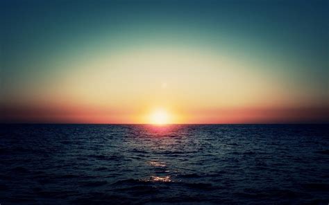 de zee met ondergaande zon achtergronden