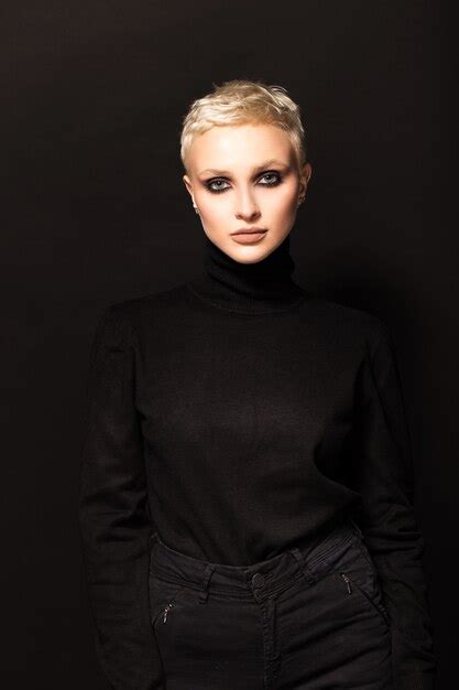 Premium Photo Short Haired Blonde In Black Clothes On A Black Wall