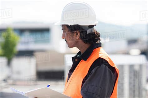 male engineer  industrial building writing  notebook side view stock photo dissolve