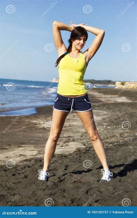 Beautiful Brunette Stretching On Beach After Jogging Stock Image