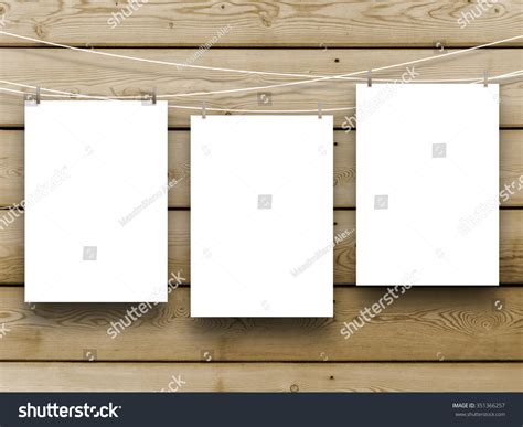 paper sheet frames hung  pegs  brown wooden boards background