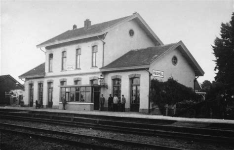 black  white photo  people standing  front   train station building