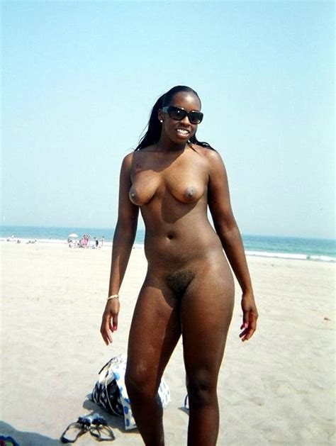 lovely skinny black chick shows her naked figure on sea beach hood tube