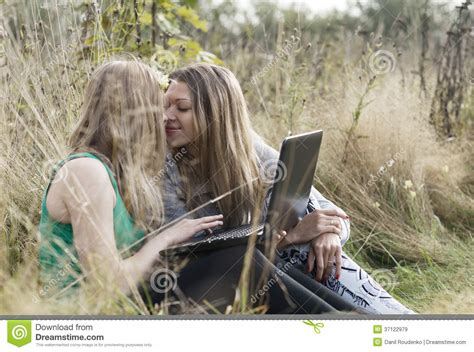 two women friends sitting outdoors together royalty free