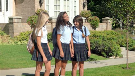 three pretty uniformed teen school girls standing sitting and chatting stock footage video