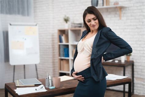 Pregnant Woman Is Experiencing Labor In Office Young Girl Is Giving