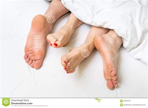 Feet Of A Couple In Bed Under The Blanket Stock Image Image Of