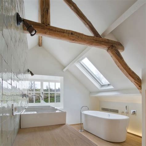 large white bath tub sitting   skylight