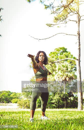 black woman doing exercise yoga stretches outdoors fitness high res