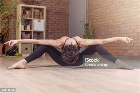 professional dancer sitting facedown stretching with her legs spread