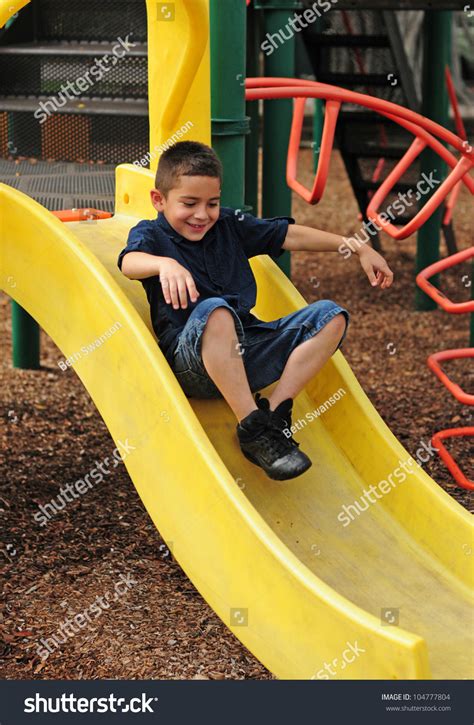 happy young boy sliding     fun  outdoor park stock