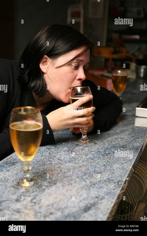 Very Drunk Female Sitting At A Bar Drinking Beer And Already Very Worse