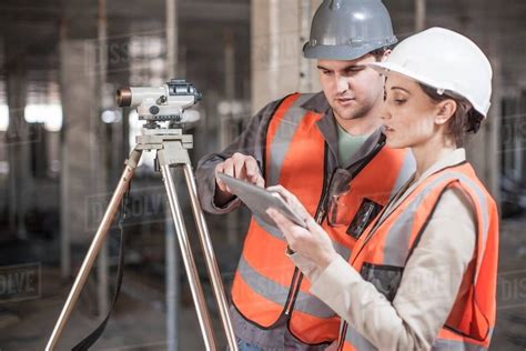 female  male surveyor  digital tablet  construction site stock photo dissolve