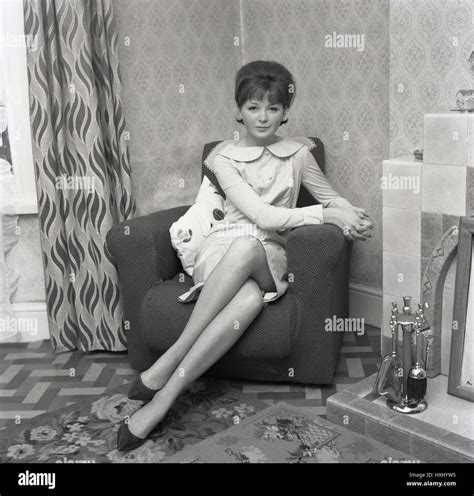 1960 histórica atractiva chica en un vestido sentado con las piernas