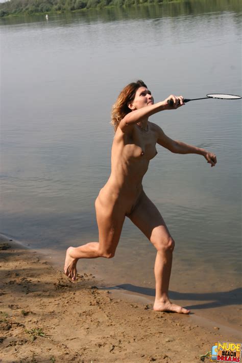 some guys and girls get together for a game of naked badminton while at a nude beach