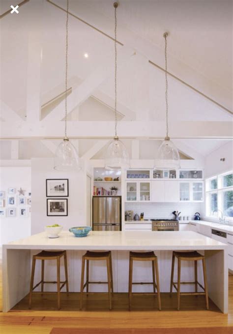 white kitchen large breakfast bar  high ceilings vaulted ceiling