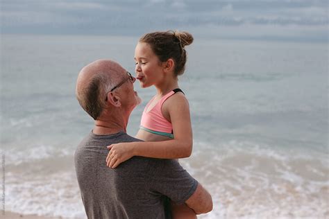 Active Happy Grandpa Having Fun With Granddaughter On Beach Vac By