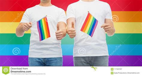 male couple with gay pride flags showing thumbs up stock image image