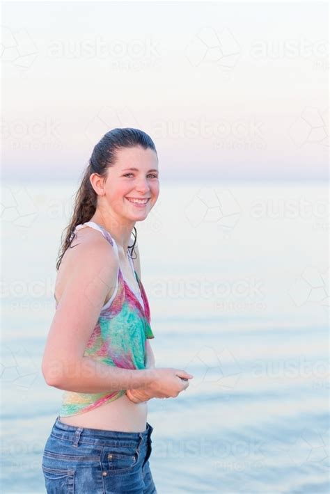 image of teenage girl on the beach with wet clothes