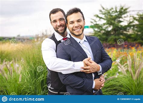 a handsome gay male couple in the park on their wedding