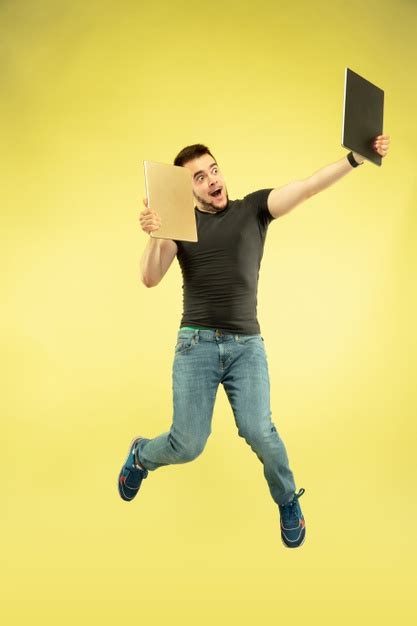 gewichtloos volledig lengteportret van gelukkige springende mens met gadgets die op gele