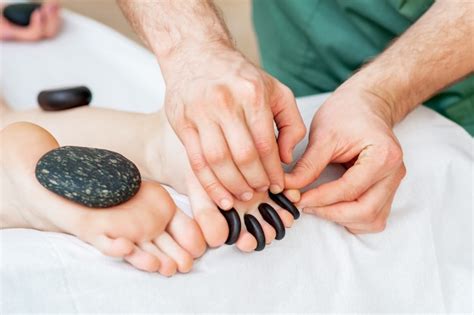 premium photo hot stone massage on toes