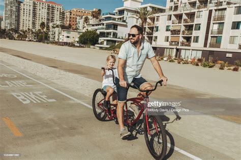 a father and daughter riding a tandem bike at long beach high res stock