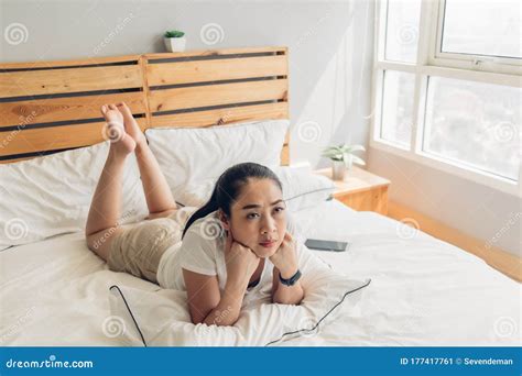 woman is lying on bed and seriously watching drama tv series stock