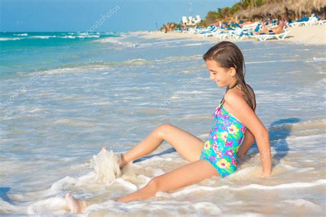Cute Hispanic Teen Sitting On A Sunny Beach In Cuba