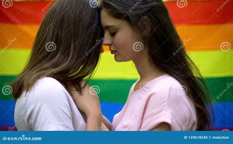 Lésbica Bonitas Que Abraçam Lovingly Bandeira Do Arco íris No Fundo