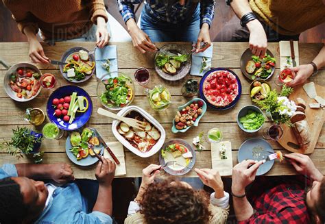 group  young people eating dinner stock photo dissolve