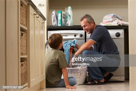 Father And Son Loading Washing Machine In Laundry Room Photo Getty Images