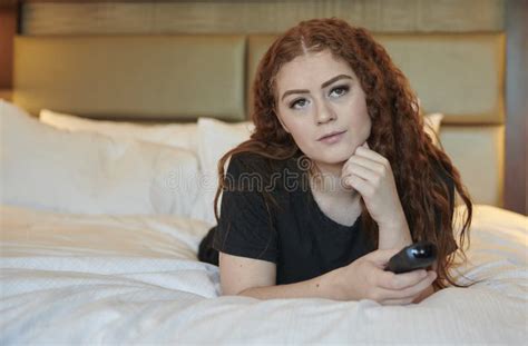 Young Redhead Woman In Bedroom Wearing Black Sweat Pants And T Shirt