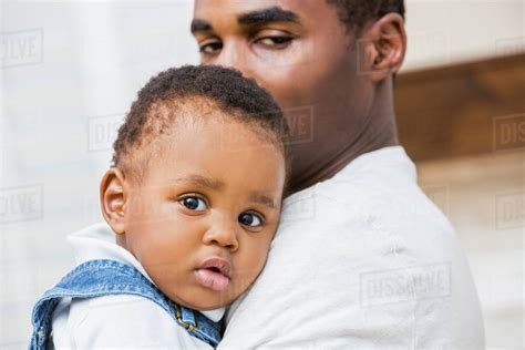 close   black father holding baby son stock photo dissolve