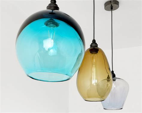three different colored glass lights hanging from the ceiling