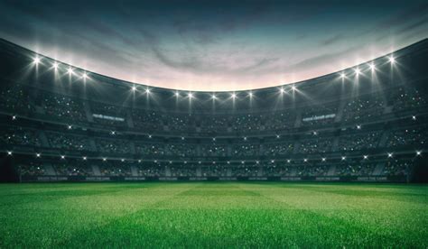 empty green grass field  illuminated outdoor stadium  fans