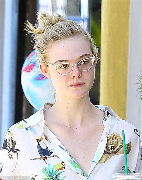 elle fanning looks spring chic in tropical print blouse and denim shorts as she steps out to