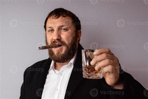 Bearded Man In Modern Coat And Shirt Smoking His Cigar 2600381 Stock