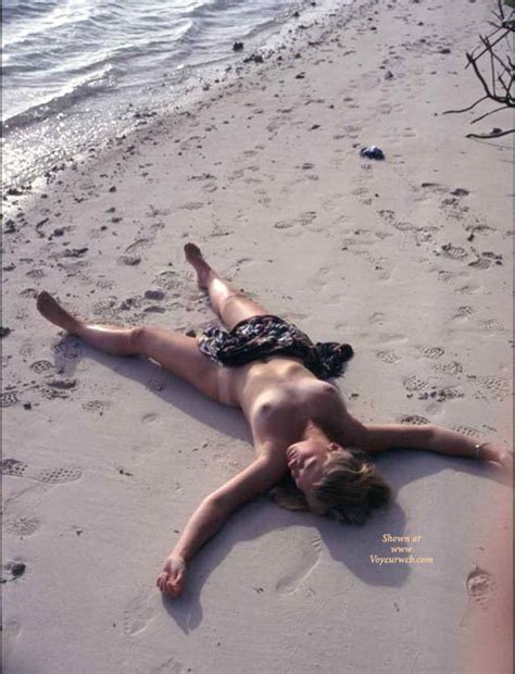 nude girl spread on the beach at voyeur web