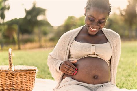 african woman caressing  pregnant belly    picnic  park stock image image