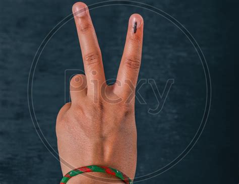 image of woman voter showing inked finger after casting vote in indian