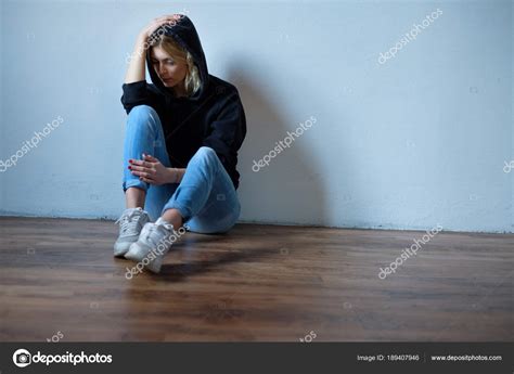 young girl hiding  face  hooded sweatshirt isolated   stock photo  tommaso