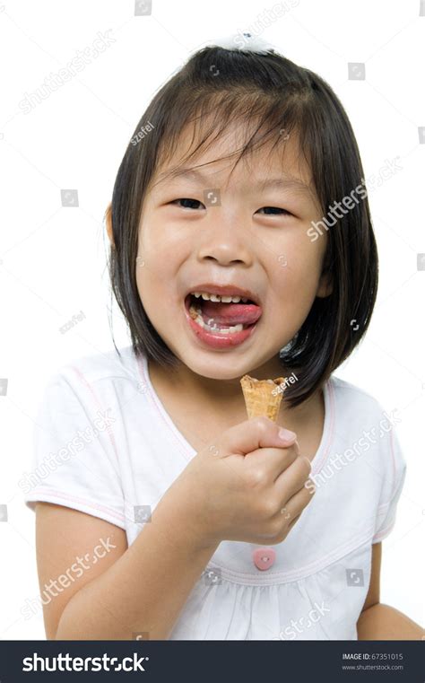 little asian girl licking her lips with an ice cream cone